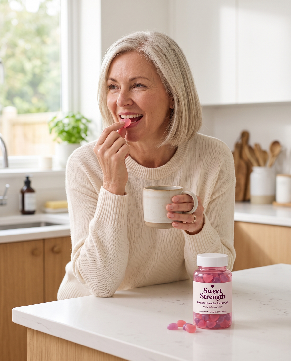 Woman taking a strawberry creatine gummy with her morning coffee